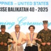 U.S. and Filipino military and civilian figures lock arms underneath "Exercise Balikatan 40-2025" banner.